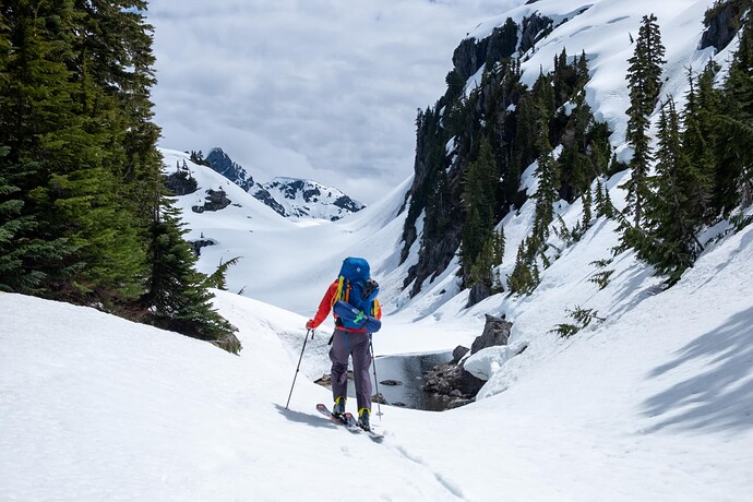 skier at outfall of little Jim lake with Mt Septimus in background (CN)