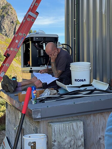 Rob studies the generator manual, new genny behind him.