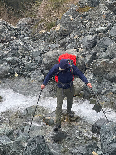 Chris scrambles across the creek.
