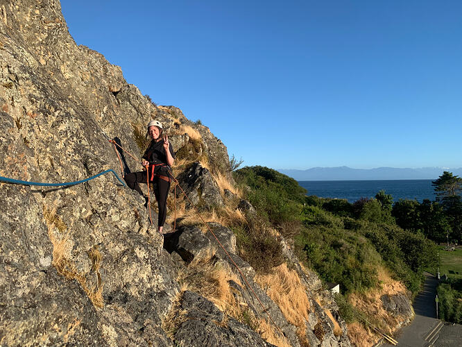 Rebecca practising cleaning the anchor, with a little extra supervision, at the top of No Crack Corner (5.6). (Photo: Hans Whitefield)